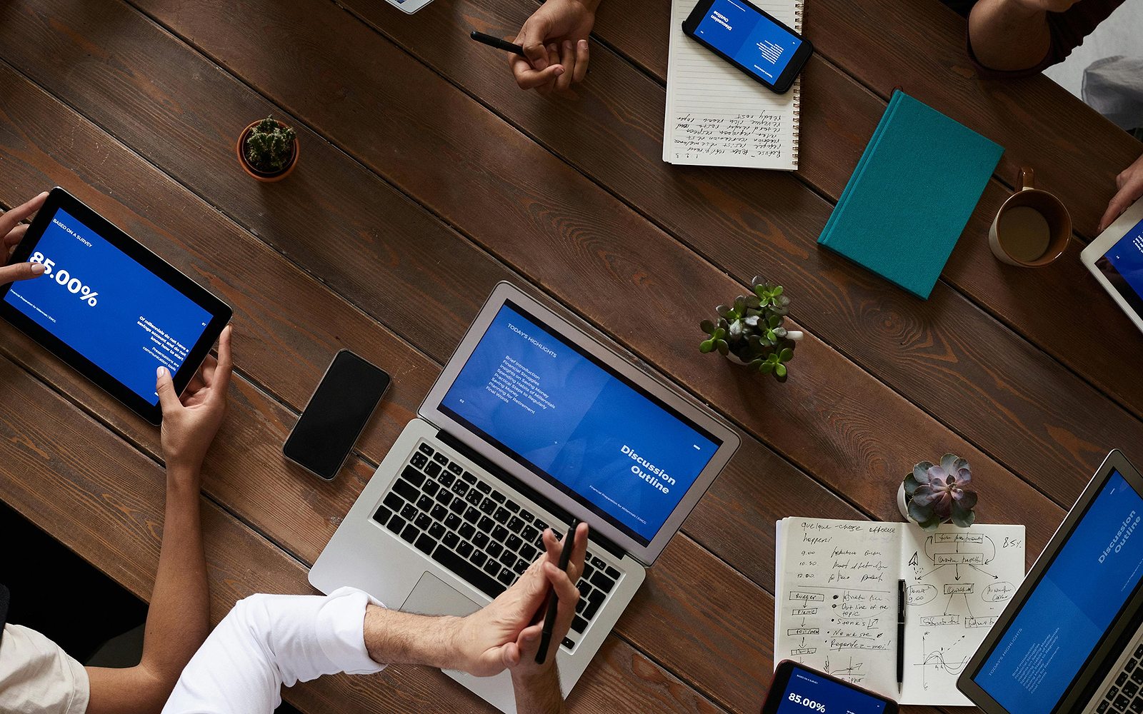 A team working with laptops and tablets around a table