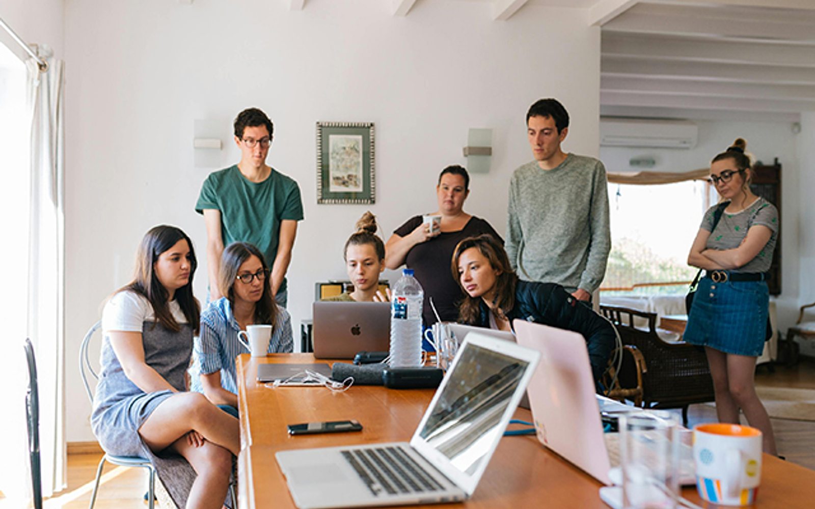 A team collaborating around a table with laptops