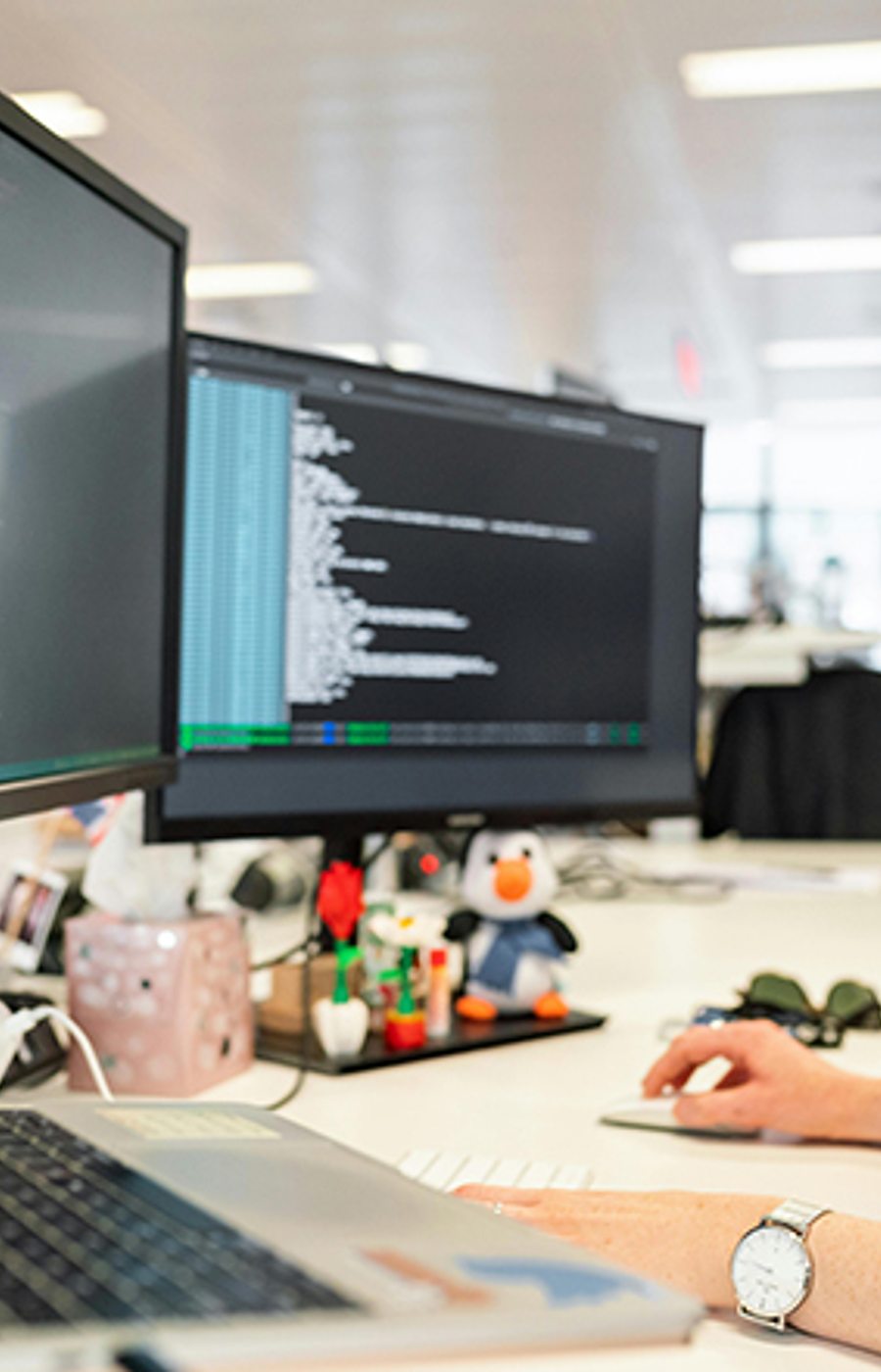 A developer working at a monitor with code on screen
